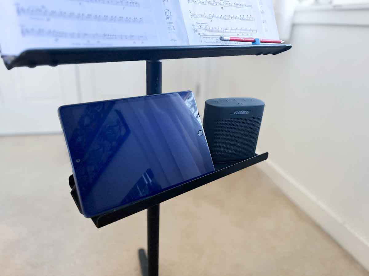 metal music stand shelf for oboe reed making tool accessories attached to a metal music stand with an iPad and Bose speaker sitting on top of it